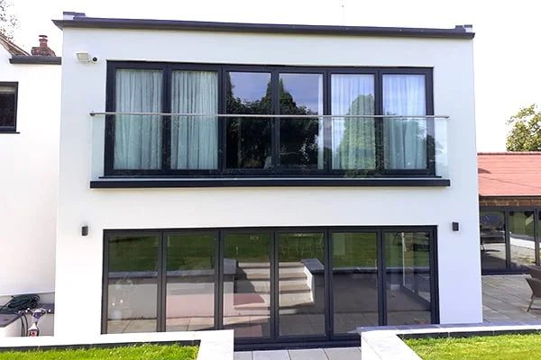 Maison avec garde-corps vitrés à la française à l'étage